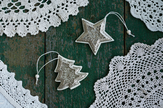Vintage Christmas toys and lace napkins on green wooden background