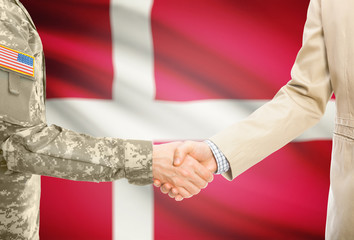 USA military man in uniform and civil man in suit shaking hands with adequate national flag on background - Denmark
