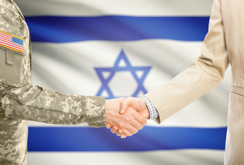 USA military man in uniform and civil man in suit shaking hands with adequate national flag on background - Israel