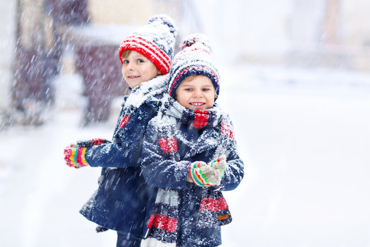 Happy children having fun with snow in winter