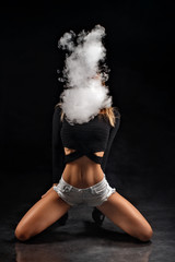 Beautiful girl vaping from e-cigarette on a black background