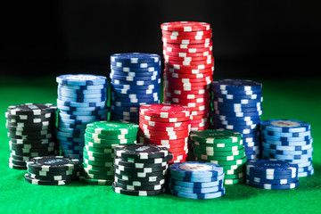   of casino chips on green table surface. gambling, fortune, game and entertainment concept - close up