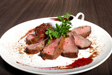 Ribeye steak with arugula on dark wooden background.