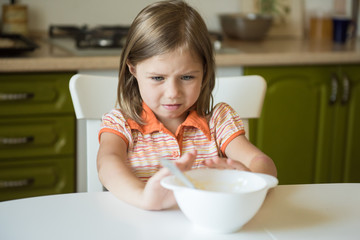 Cute little girl refuses to eat, pushes the plate