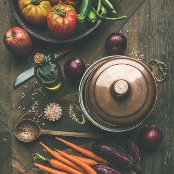 Fall cooking background. Autumn ingredients for Thanksgiving day dinner preparation. Flat-lay of green beans, corn cobs, carrot, tomatoes, eggplant over wooden table, top view, square crop