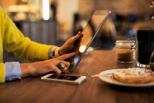 Woman using tablet computer in cafe