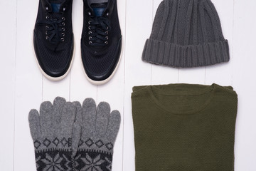Men's winter casual outfits with accessories on wooden background