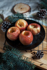 baked apples for the new year, fir-tree, cones, honey on a black background