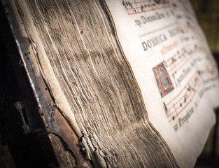 detail of the pages of a church choir books on a wooden lectern. Very old deteriorated books 16th...