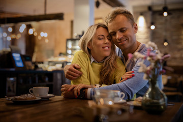 Couple embracing in cafe