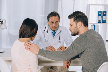 Fototapeta premium boyfriend hugging and supporting girlfriend at clinic