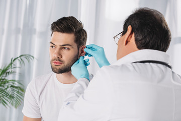 Obraz premium doctor examining male patient ear