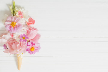 flowers in waffle cone on wooden background