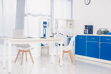 table with chairs and shelves with documents at working place in clinic