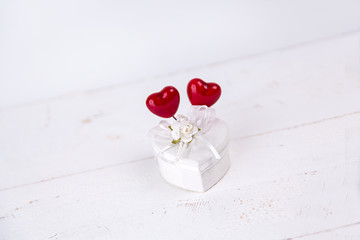 White jewel box with heart shape and red hearts