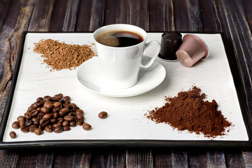 Espresso cup, coffee beans, ground coffee, coffee capsule and instant coffee on a white background