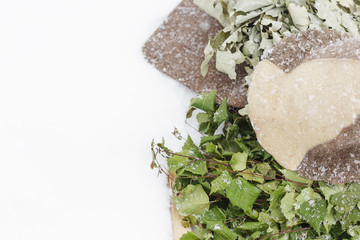 Birch broom and hat of felt on the snow