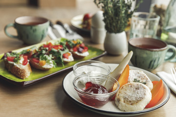 close-up view of delicious cheesecakes with jam and sandwiches for breakfast