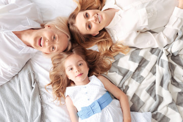 Our family. Top view of a nice pleasant friendly family lying together and smiling while feeling happy