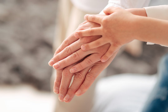 Between Generations. Hands Of Three Generations Being Held Together While Shoeing Their Togetherness And Unity