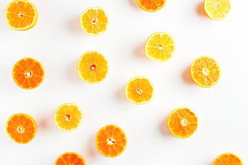 halves of orange and yellow tangerines on a white background