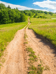 Rough And Bumpy Dirt Road Going Downhill