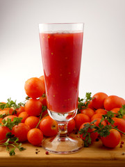 Tamoto Juice with pepper and cherry tomatoes on wooden plank isolated