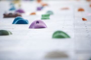 Grey wall with climbing holds in gym