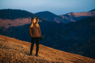 Naklejka premium Shot of a young woman looking at the landscape while hiking in the mountains. Girl tourist in mountain. Recreation fitness and healthy lifestyle outdoors in beautiful nature.