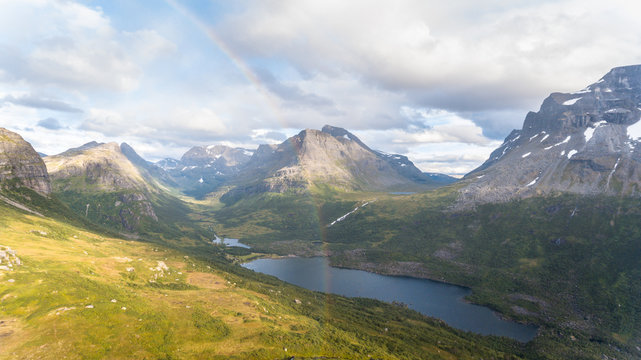 Beautiful sunny day in the mountains. Rainbow shining over mountain valley in Norway.