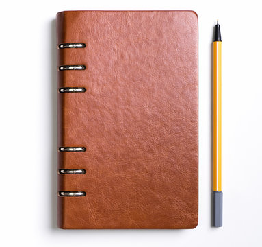Leather cover notebook with a yellow pen on white background
