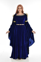 full length portrait of girl wearing long blue velvet gown and fur lined cloak, standing pose  on white background.