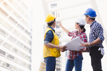 Engineers man and woman working on plan building construction in city