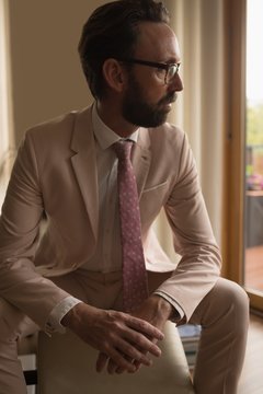 Man in suited sitting on arm chair