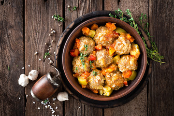 Meatballs stewed with vegetables on wooden table, top view