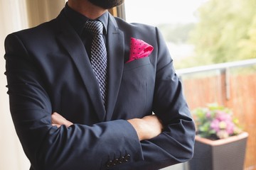 Man in full suit standing with arms crossed