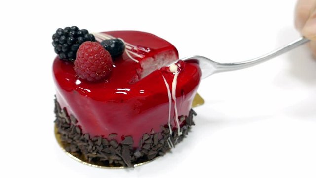 A mono portion cake lying on a table and a person starts to eat it with a fork...