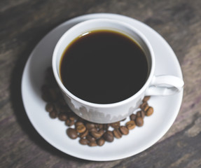 Cup of coffee on wooden table, top view