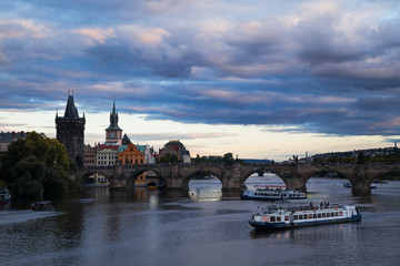 Panoramic view on Vltava river with ships and ferryboat along it and historical center of Prague,buildings and landmarks of old town, Prague, Czech Republic. Beautiful Prague at Twilight.