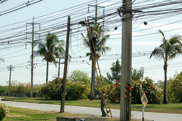 Asian Electronics technician he working to install internet fiber optic and climbing by the bamboo...