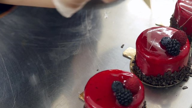 A professional confectioner decorating several mono portions...