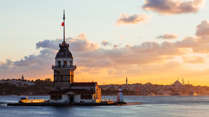 Maiden Tower or Kiz Kulesi with floating tourist boats on Bosphorus in Istanbul at sunset
