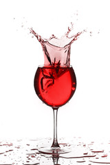 Wine glass with liquid splash on white background