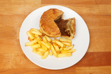 Steak pie and chips on a tabletop