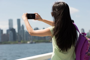 Young woman taking a photograph from the ferry