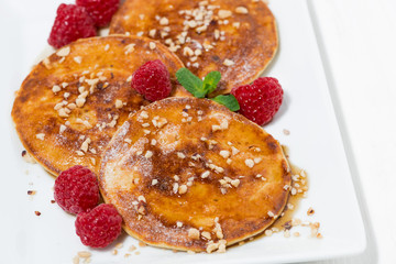 pancakes with raspberries on white plate