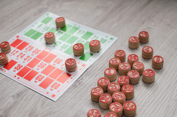 Developing bingo table game old lotto game with wooden elements and cards bingo on a wooden background