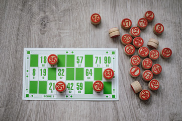 Developing bingo table game old lotto game with wooden elements and cards bingo on a wooden background