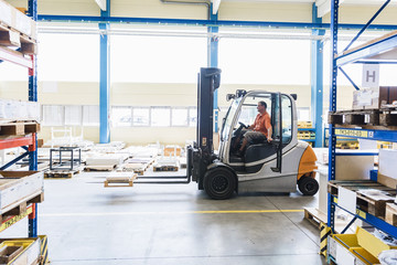 Man on forklift in factory warehouse