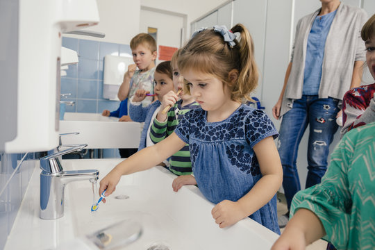 Children brushing their teeth in bathroom of a kindergarten